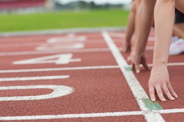 Mensen bijgesneden klaar om te racen op het atletiekveld