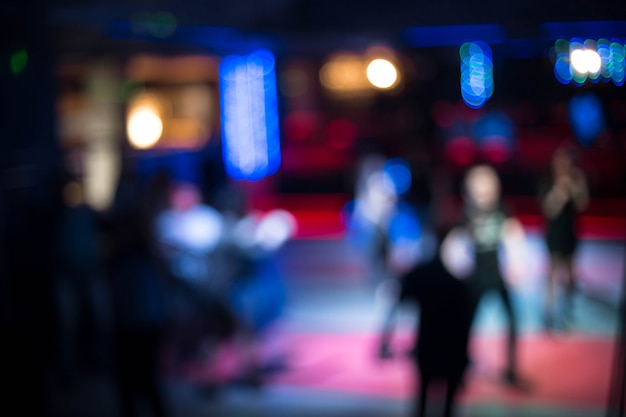 Mensen dansen met plezier en ontspannen in een nachtclub wazige achtergrond. Mooie wazige lichten op de dansvloer