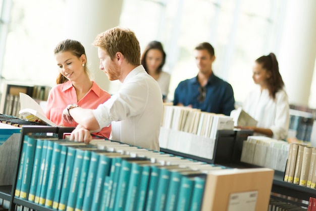 Mensen die bij de boekenkasten in de bibliotheek staan