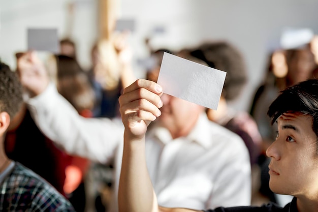 Mensen die blanco stembiljetten tonen