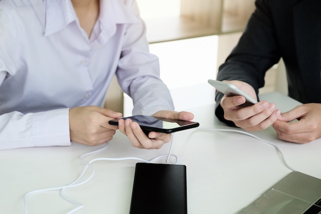 Mensen die een powerbank gebruiken om naar hun mobiele telefoon op te laden