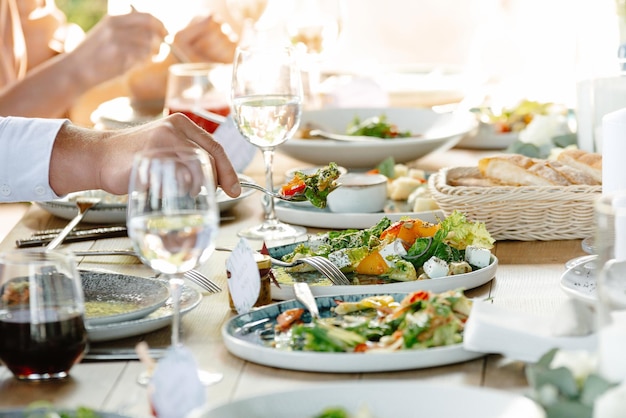 Mensen die in het restaurant eten, een restaurant met een klassieke Europese keuken, alleen de handen van mensen zijn te zien?