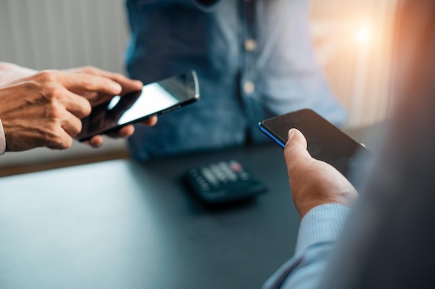 Foto mensen die mobiele telefoons gebruiken aan tafel