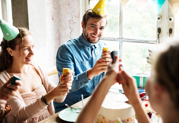 Mensen die partij gebruiken die bij de viering van de vriendverjaardag knallen