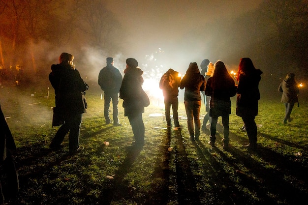 Foto mensen die's nachts in de winter op een verlicht veld staan