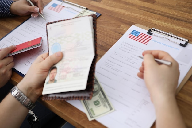 Mensen die visumaanvraagformulieren invullen met persoonlijke paspoorten bij de ambassade