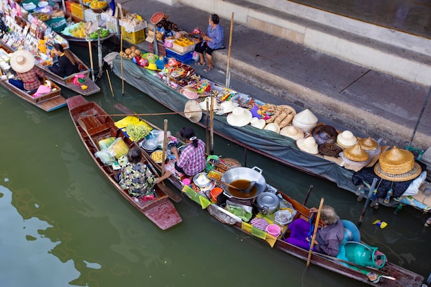 Mensen die voedsel en groente verkopen op de drijvende markt Damnoen Saduak, niet ver van de stad Bangkok, Thail