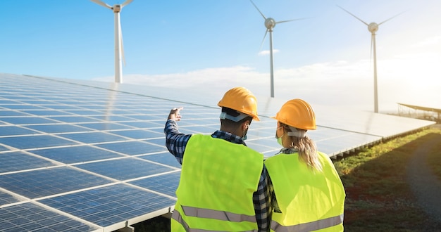 Mensen die voor een alternatieve energieboerderij werken terwijl ze veiligheidsmaskers dragen - Focus op helmen