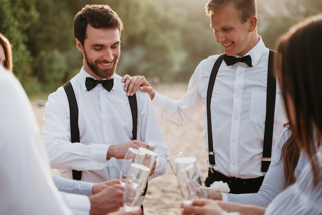 Foto mensen die wat drinken op een strandhuwelijk