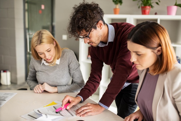 mensen en bedrijfsconcept - gelukkig zakelijk team met papieren die op kantoor bijeenkomen