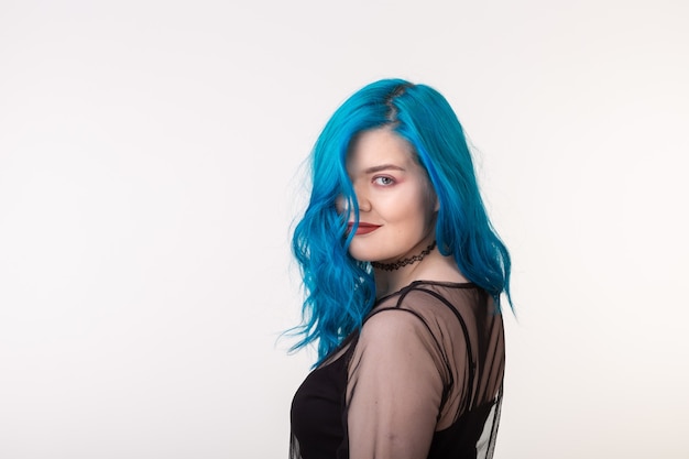 Mensen en mode-concept mooie vrouw met blauw haar poseren over witte muur