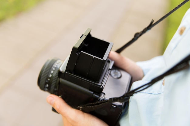 mensen, fotografie, technologie, vrije tijd en levensstijl - close-up van mannelijke fotograaf met digitale camera op straat in de stad