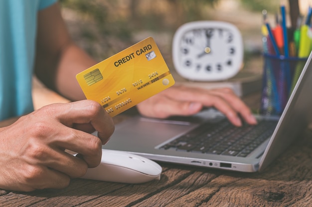 Mensen gebruiken creditcards om via notebooks online te winkelen.