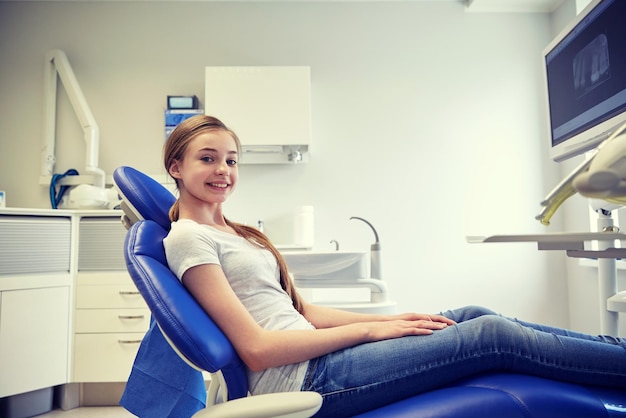 mensen, geneeskunde, stomatologie, tandheelkunde en gezondheidszorgconcept - gelukkig geduldig meisje op het kantoor van de tandheelkundige kliniek