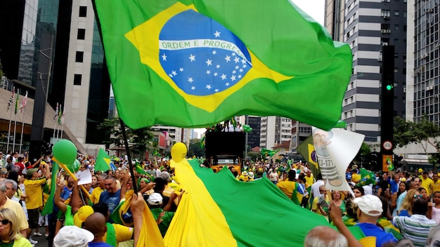 Foto mensen genieten met de braziliaanse vlag tijdens een festival in de stad