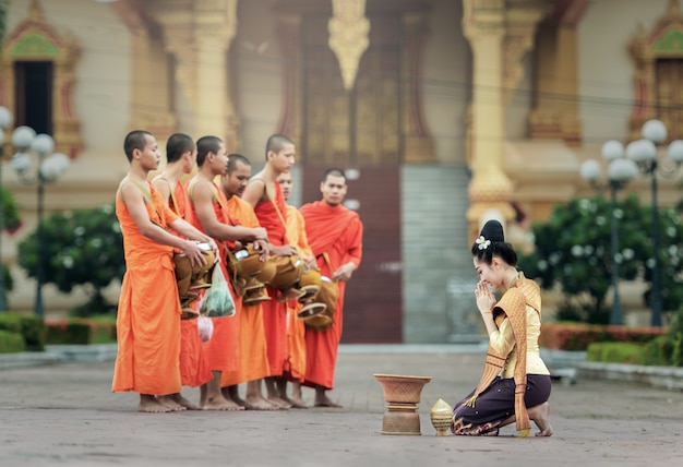 Mensen geven voedseloffers aan boeddhistische monniken in Vientiane, Laos.