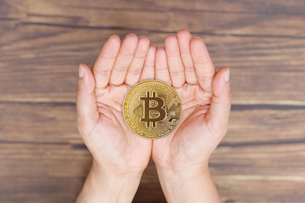 Mensen Hand geven en ontvangen liefde voor BTC Bitcoin op lege palmhanden Toekomst van Crypto-valuta zal Heritage Gift to Family Concept vertegenwoordigen Liefdesaandeel met technologie over houten achtergrond