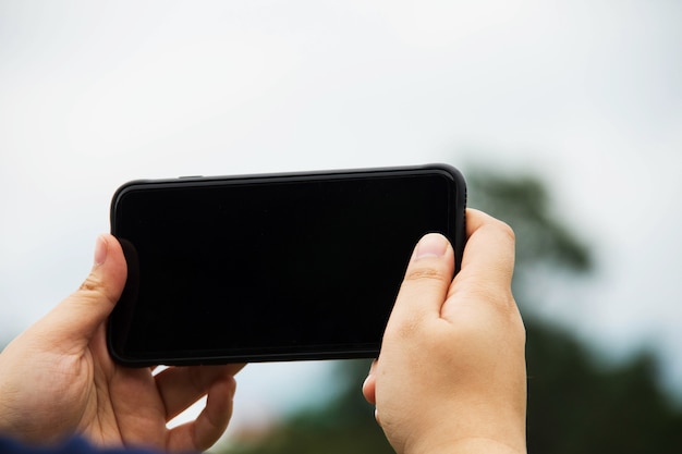 mensen houden van smartphone met de natuur achtergrond.