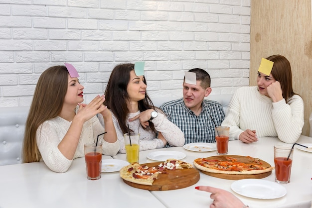 Mensen in café spelen spel met stickers op voorhoofd