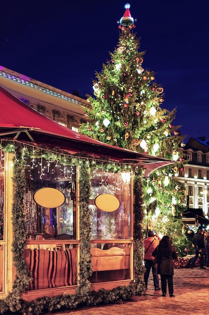 Mensen in de buurt van een van de kraampjes op de kerstmarkt in Riga, Letland. De markt vindt elk jaar in december plaats. Daar kunnen mensen feestelijke goederen kopen