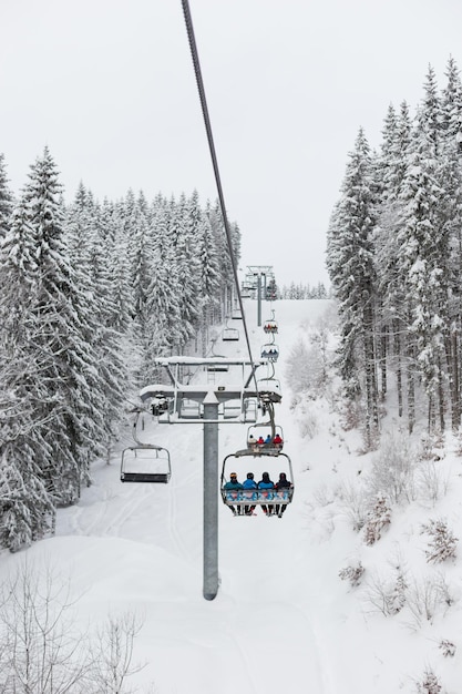 Mensen in een skigebied gaan bergop met een stoeltjeslift.