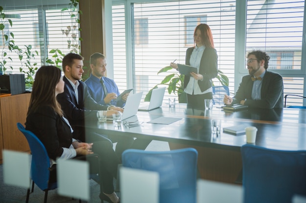 Mensen in kantoor luisteren naar presentatie