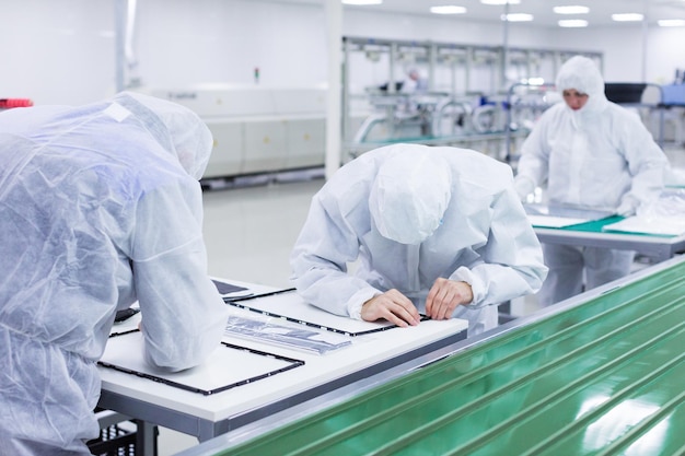 Foto mensen in witte isolerende kostuums die in laboratorium werken