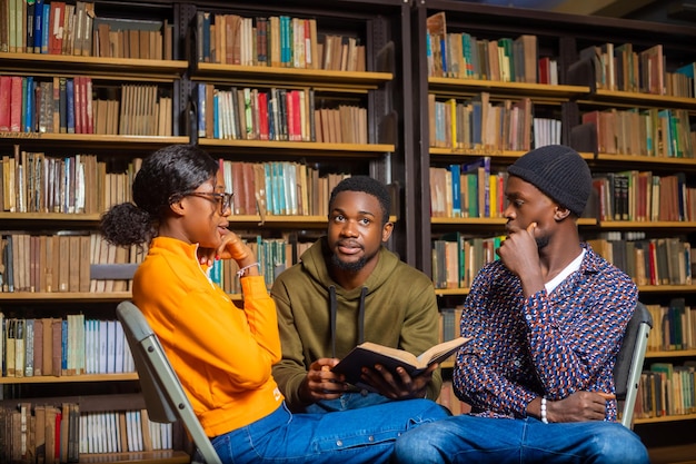 Mensen kennisonderwijs en schoolconcept groep studenten die boeken lezen en zich voorbereiden op examen in bibliotheek