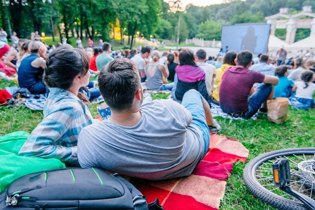 Mensen kijken naar film in openluchtbioscoop in stadspark