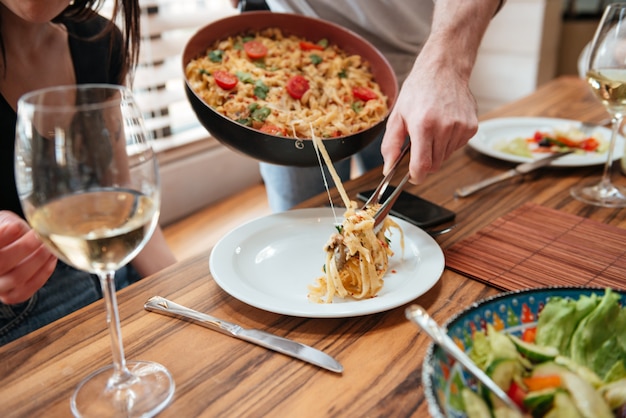 Mensen kokend diner en het zetten van voedsel in de plaat