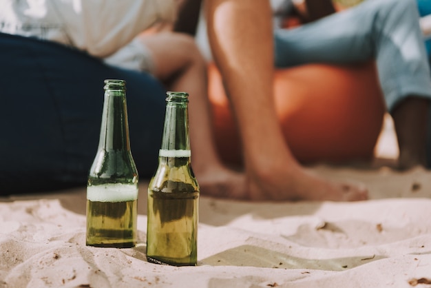 Mensen kregen bierflesjes in het zand bij Beach Party