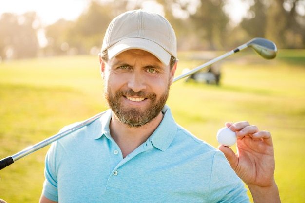 Foto mensen levensstijl. man na spel op groen gras. zomer activiteit. professionele sport buiten. mannelijke golfspeler op professionele golfbaan. gezicht portret van golfer in pet met golfclub.