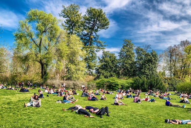 Mensen liggend op het gras in Parco Sempione in Milaan, Italië