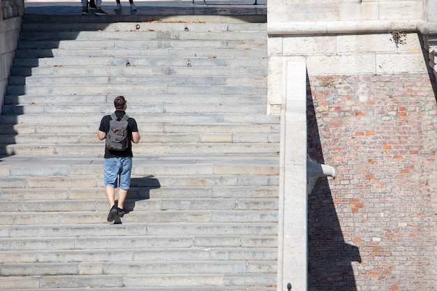 Mensen lopen door stenen trappen met rugzak