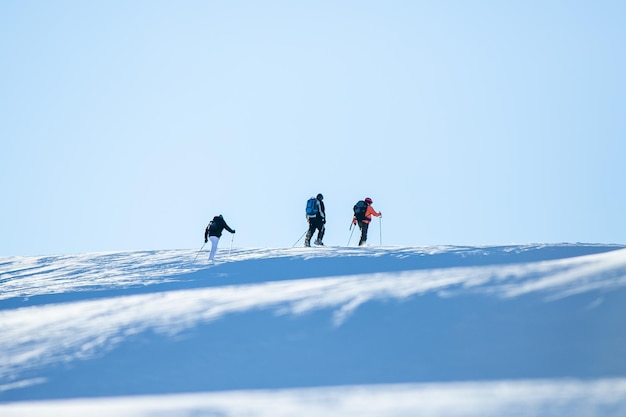 Mensen lopen op besneeuwde berg tegen de hemel