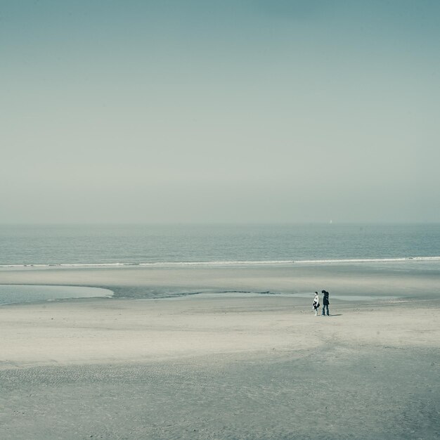 Mensen lopen op het strand.