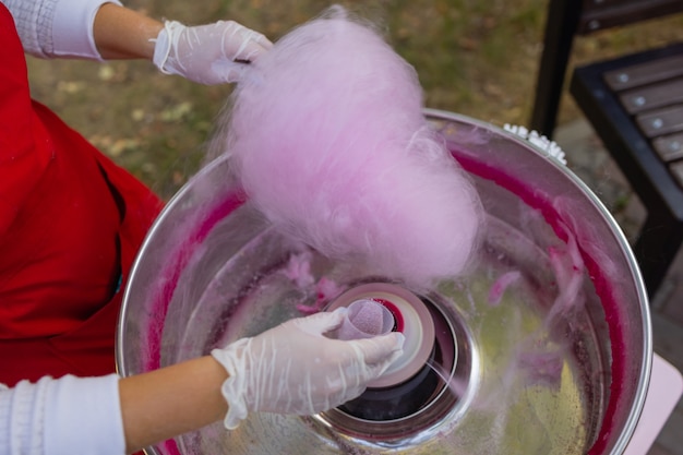 Mensen maken suikerspin voor kinderen close-up