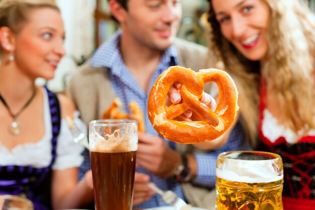 Mensen met bier en krakeling in beierse pub