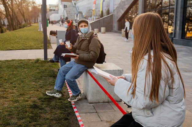 Mensen met masker op afstand van elkaar