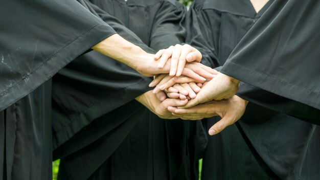 mensen met zwarte toga gaan hand in hand bij het groeperen.