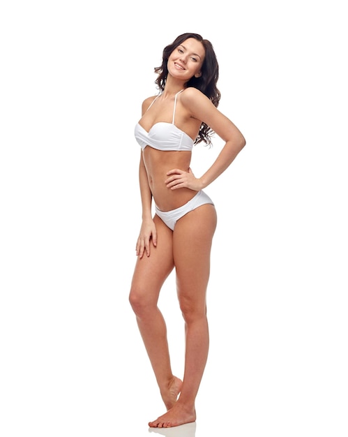 mensen, mode, badmode, zomer en strandconcept - gelukkige jonge vrouw in wit bikinizwempak