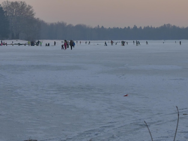 Foto mensen op een met sneeuw bedekt landschap bij zonsondergang