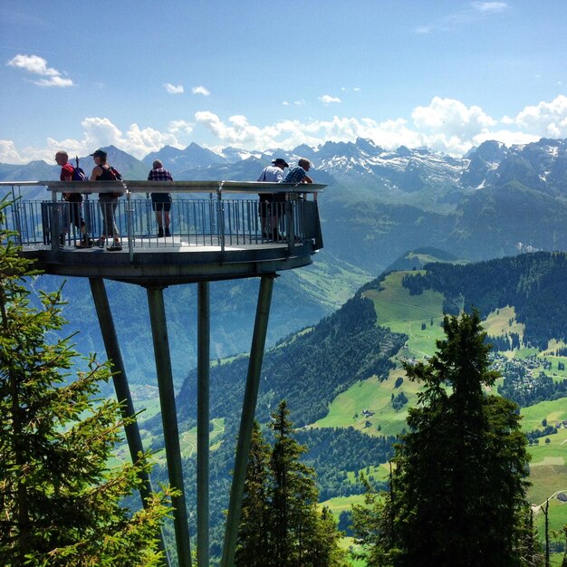 Foto mensen op een observatiepunt tegen de zwitserse alpen