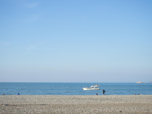 Mensen op het lentekiezelstrand Vakantie op het strand Ontspanning op zee Rotsachtige kust Kiezelstrand