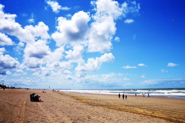 Foto mensen op het strand tegen de lucht