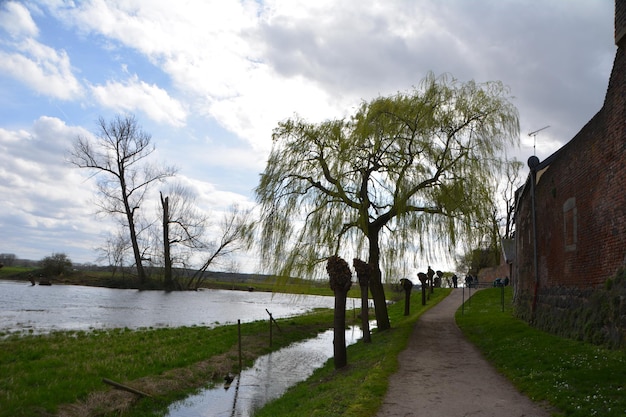 Foto mensen op het voetpad langs de rivier tegen de lucht