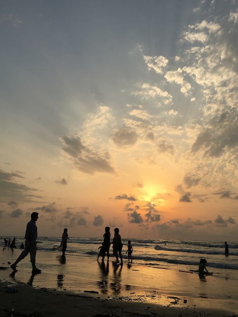 Mensen op zee strand bij zonsondergang met plezier