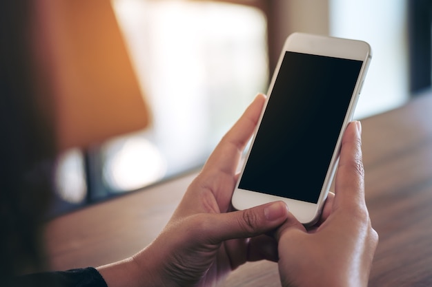 Mensen overhandigen met behulp van mockup slimme telefoon in café