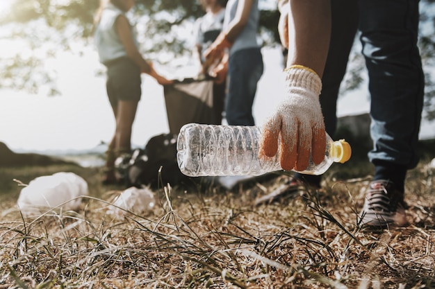 Mensen pakken afval op en stoppen het in een plastic zwarte zak om te reinigen