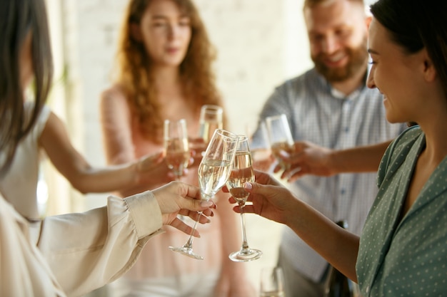 Mensen rammelende glazen met wijn of champagne. Fijne vrolijke vrienden